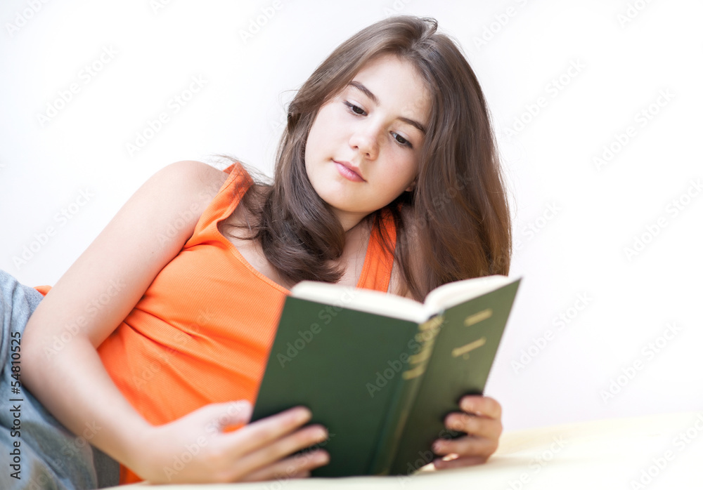 Teenage girl lying and reading a book Teenage girl lying and reading a book