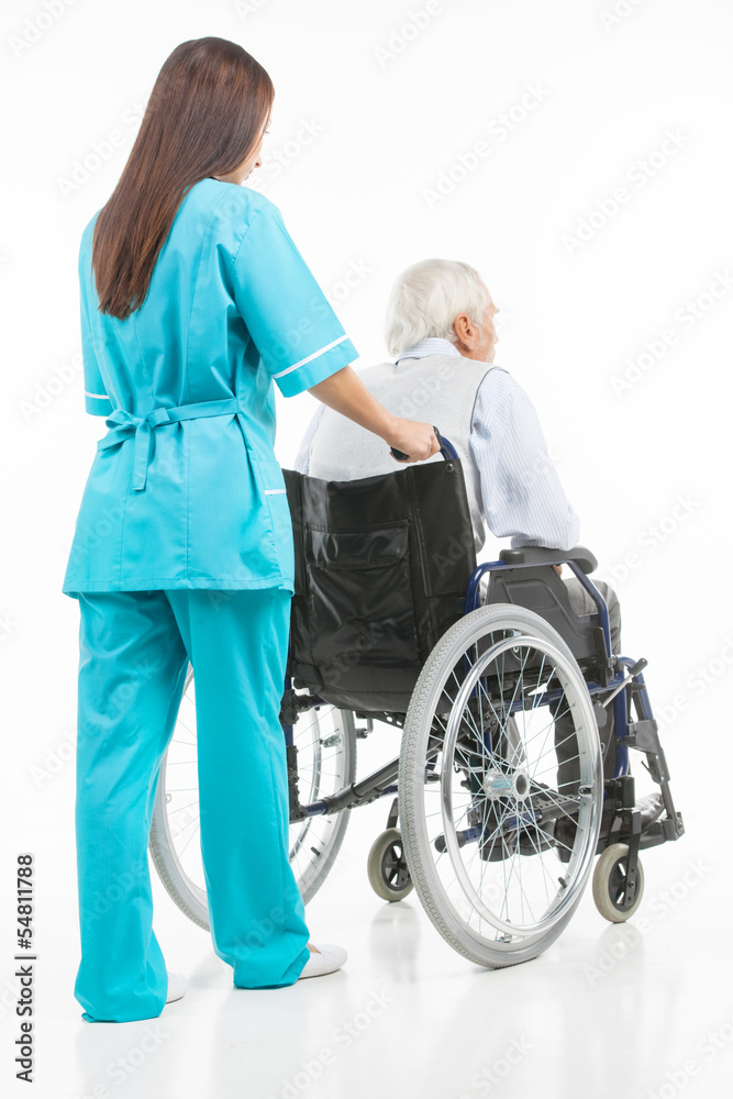 Taking care of seniors. Rear view of confident young nurse walki Taking care of seniors. Rear view of confident young nurse walki