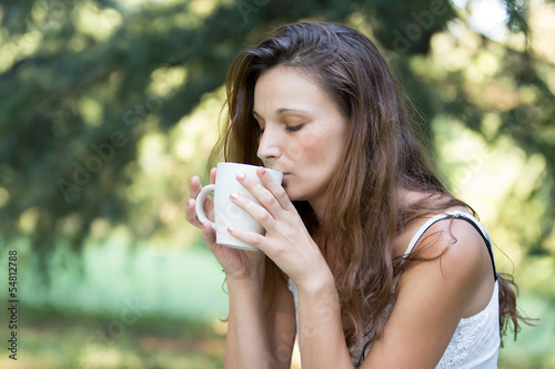 Beautiful Brunette Girl Drinking Tea or Coffee. Woman with Cup a