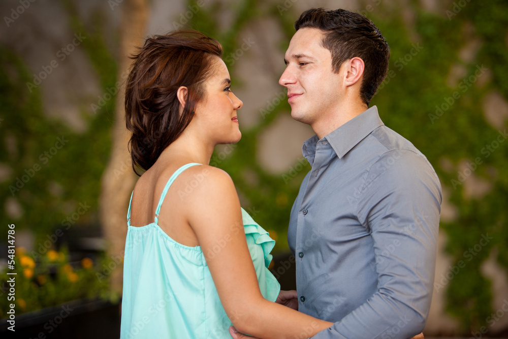 Good looking Hispanic couple looking at each other on a terrace Good looking Hispanic couple looking at each other on a terrace
