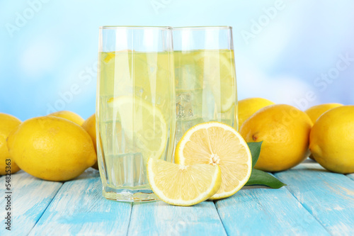 Delicious lemonade on table on blue background