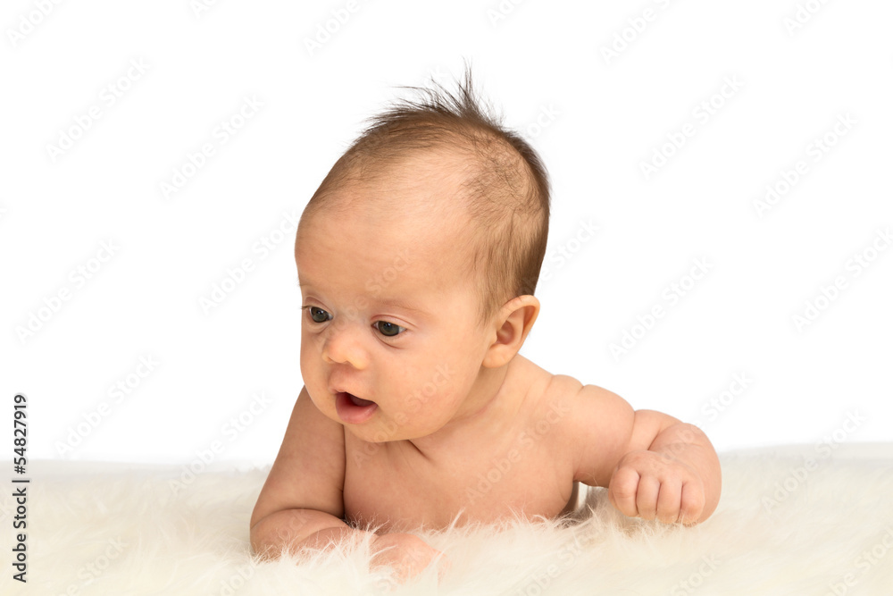 Newborn baby girl lying on her belly on a sheepskin Newborn baby girl lying on her belly on a sheepskin