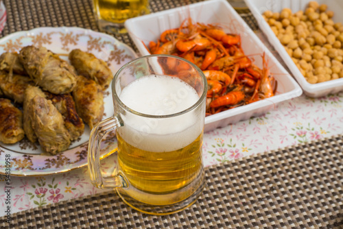 Beer, shrimp, pea, and other appetizers on a table