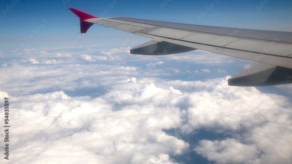 Wing of airplane and clouds from window Wing of airplane and clouds from window