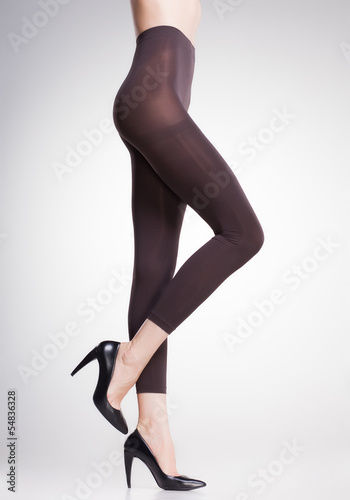 brown tights on sexy woman legs isolated on grey