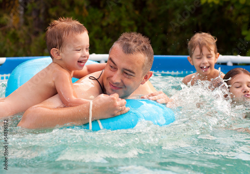Father and his children having fun in the swimming pool © Solid photos