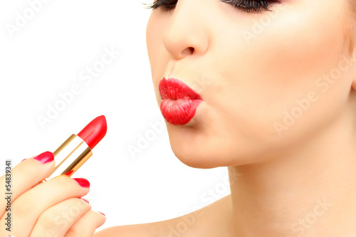 beautiful woman is applying her lips with red lipstick © Africa Studio