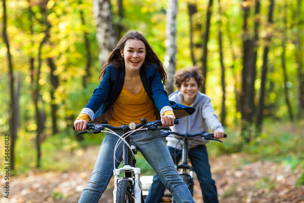 Fototapeta premium Urban biking - teens riding bikes in city park
