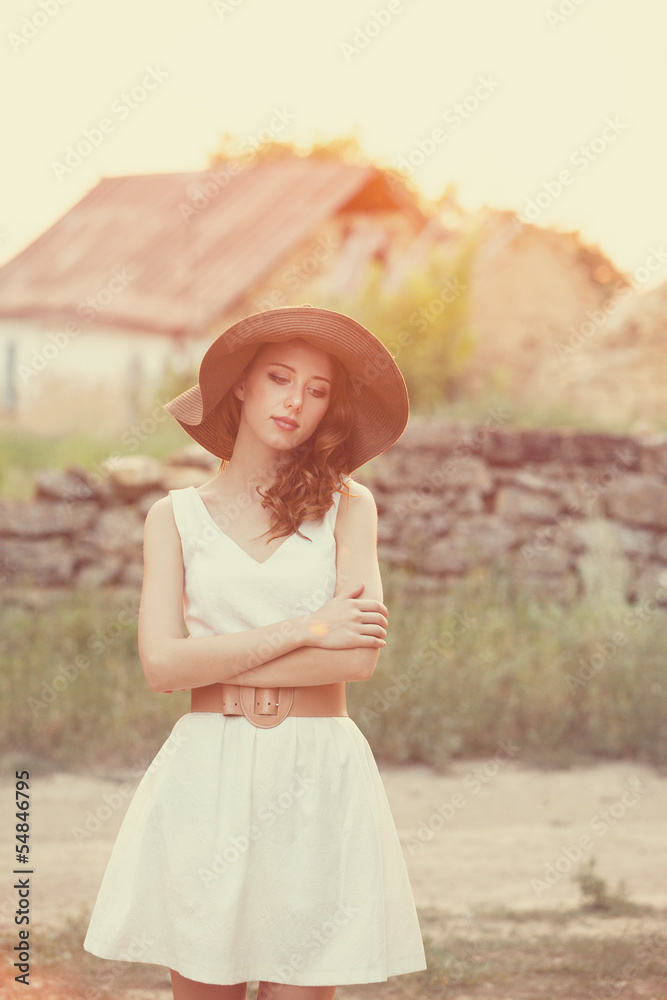 Redhead girl at outdoor. Old country house at background.