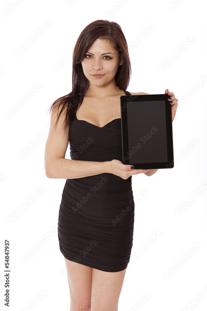 Young woman in a little black dress holds up a blank tablet comp