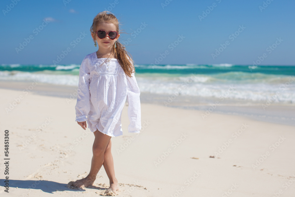Adorable toddler girl in white dress walking at exotic beach Adorable toddler girl in white dress walking at exotic beach