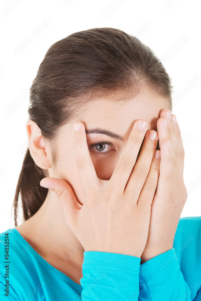 Fototapeta premium Shy teenage girl peeking through covered face