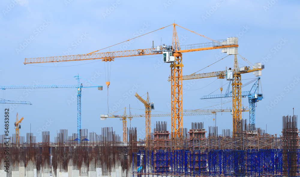 Construction site with multiple cranes on a blue background. Construction site with multiple cranes on a blue background.
