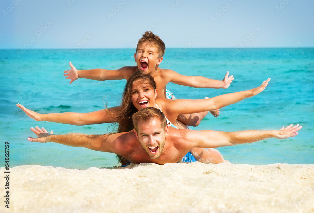 Happy Young Family with Little Kid Having Fun at the Beach Happy Young Family with Little Kid Having Fun at the Beach