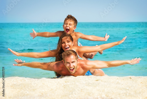 Happy Young Family with Little Kid Having Fun at the Beach