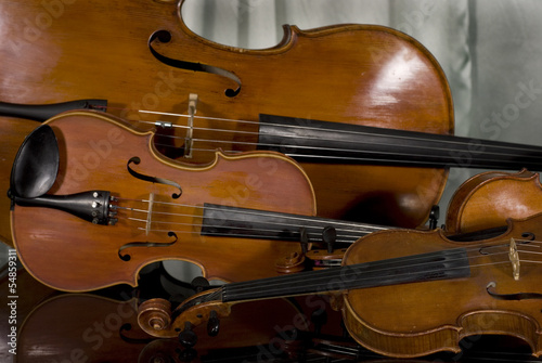 Two Violins, Viola and Cello on Piano on Curtain Background