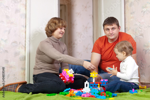 parents and child plays with meccano