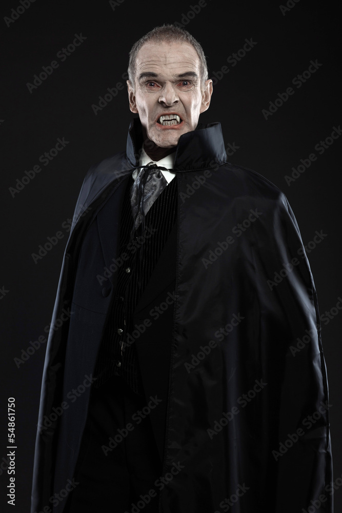 Naklejka premium Dracula with black cape showing his scary teeth. Vamp fangs. Stu