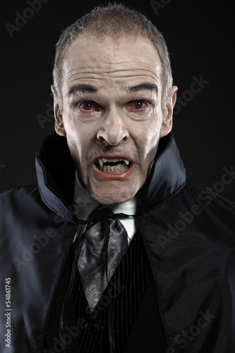 Dracula with black cape showing his scary teeth. Vamp fangs. Stu © ysbrandcosijn