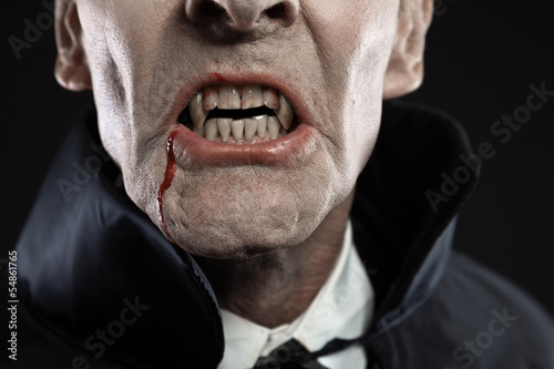 Close-up of dracula with black cape showing his scary teeth. Vam photo