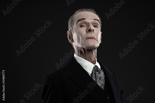 Foto Scary count dracula in black suit. Pale head. Studio shot agains