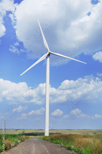 Windmill in field on blue sky background © Africa Studio