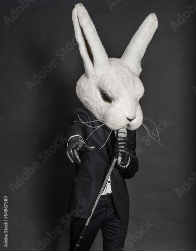 man in rabbit mask . black suit sing on dark background
