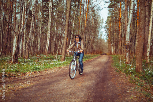Young woman riding bicycle on a forest