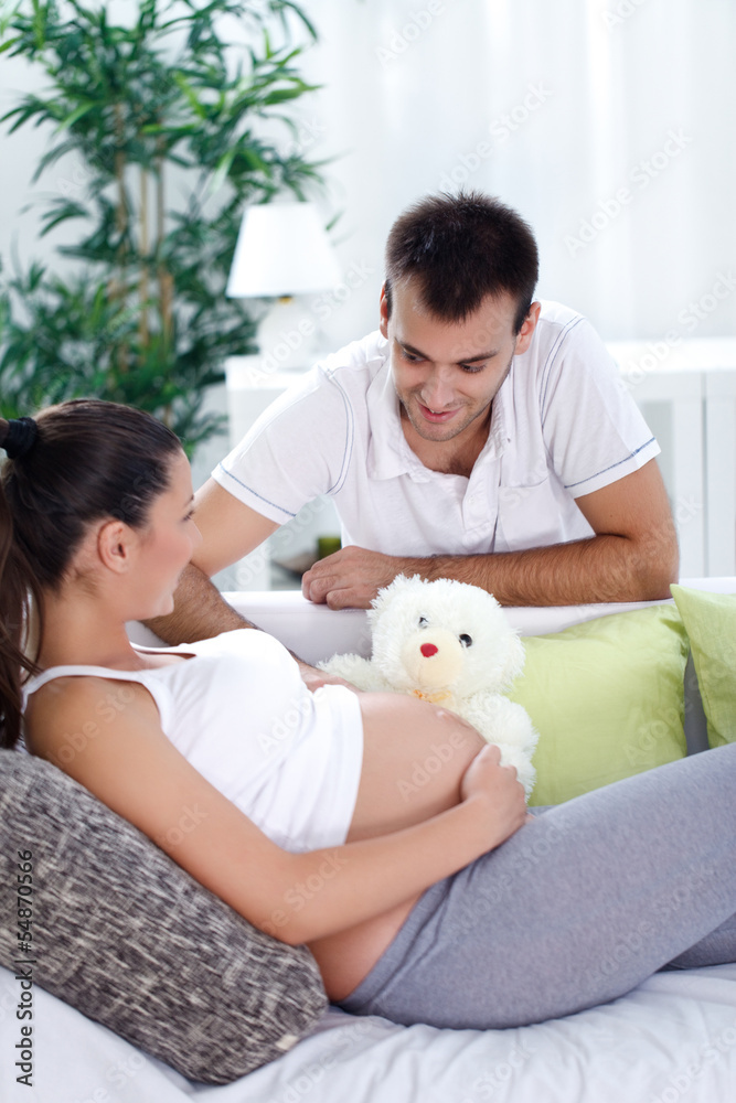 pregnant woman and of her husband on a sofa at home pregnant woman and of her husband on a sofa at home