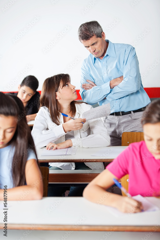 Angry Teacher Looking At Student During Examination Angry Teacher Looking At Student During Examination
