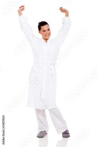 young woman in pajamas stretching arms
