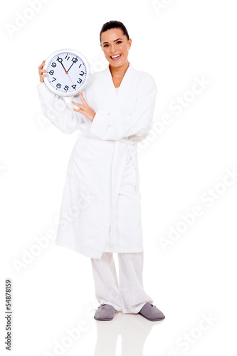 young woman in bathrobe holding clock