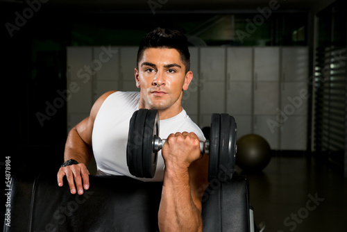 Powerful muscular man lifting weights