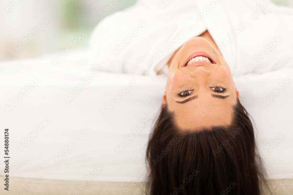 Fototapeta premium happy young woman lying on bed