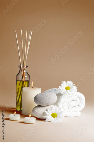 spa decoration with flowers, stones, candles and massage oil