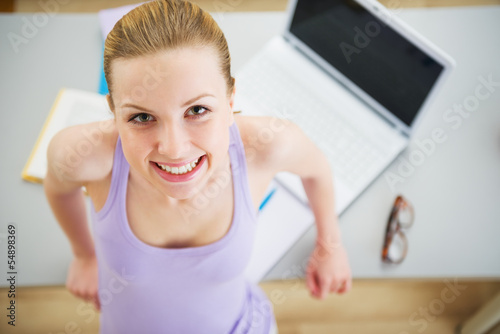 Portrait of smiling young woman studying in kitchen