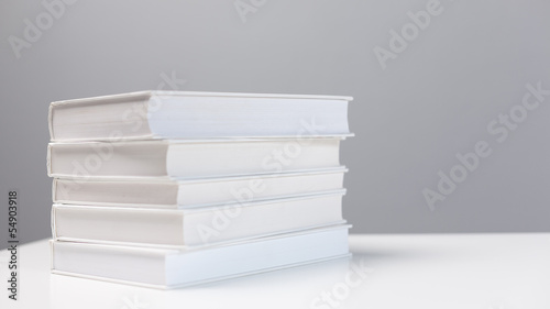 Stack of books on a white desk