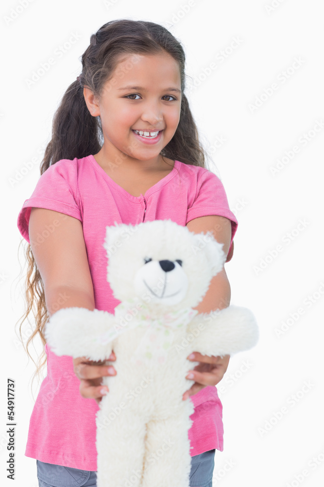 Smiling little girl showing her teddy bear to camera Smiling little girl showing her teddy bear to camera