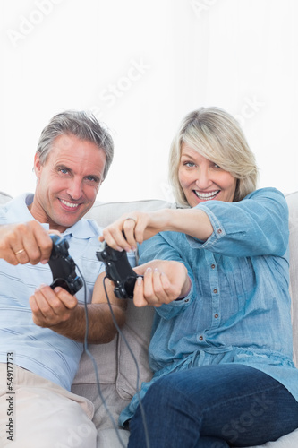 Couple playing video games together on the sofa