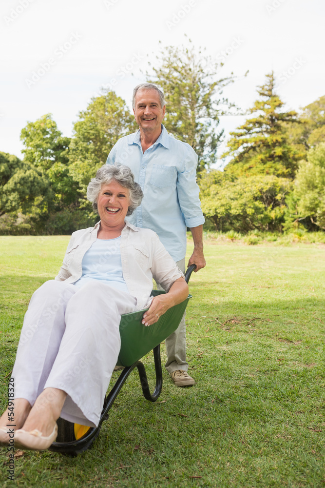 Funny man pushing his wife in a wheelbarrow Funny man pushing his wife in a wheelbarrow