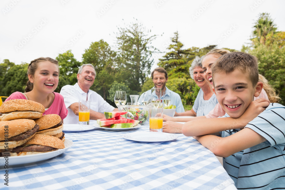 Extended family having dinner outdoors at picnic table Extended family having dinner outdoors at picnic table