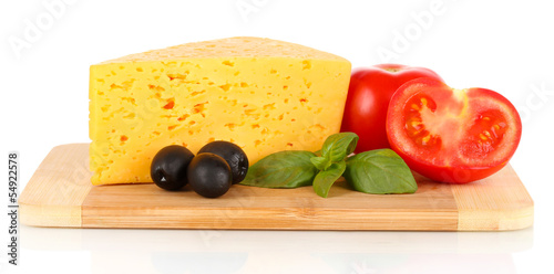 Cheese, basil and vegetables on cutting board isolated on white