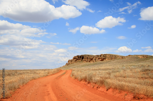 Dirt road orange prairie  going to the blue sky