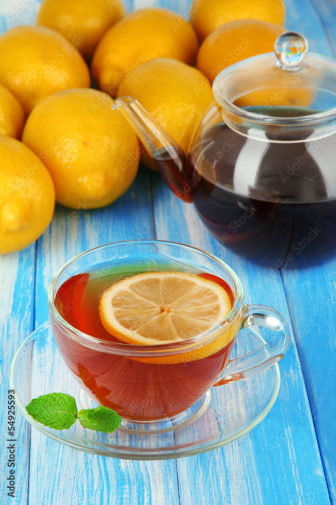 Cup of tea with lemon on table on blue background Cup of tea with lemon on table on blue background