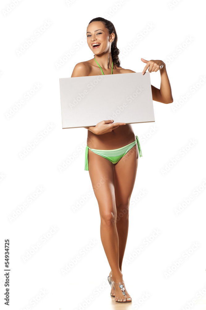 pretty young brunette in a bikini holding a blank board pretty young brunette in a bikini holding a blank board