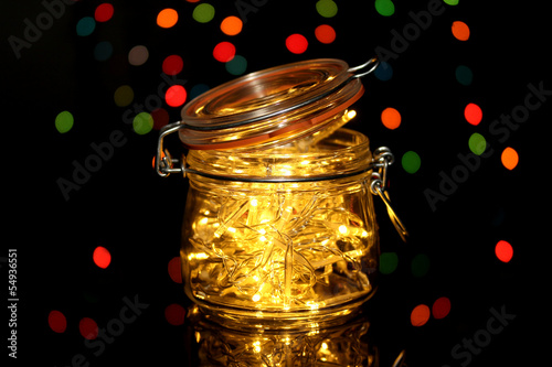 Christmas lights in glass bottle on blur lights background