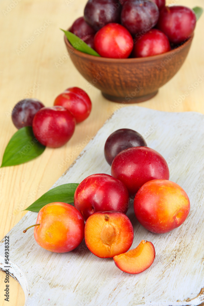 Ripe plums on wooden table close-up Ripe plums on wooden table close-up