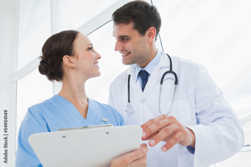 Cheerful doctor and surgeon looking at each other