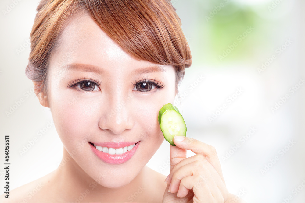 beautiful woman holding cucumber slices on face beautiful woman holding cucumber slices on face
