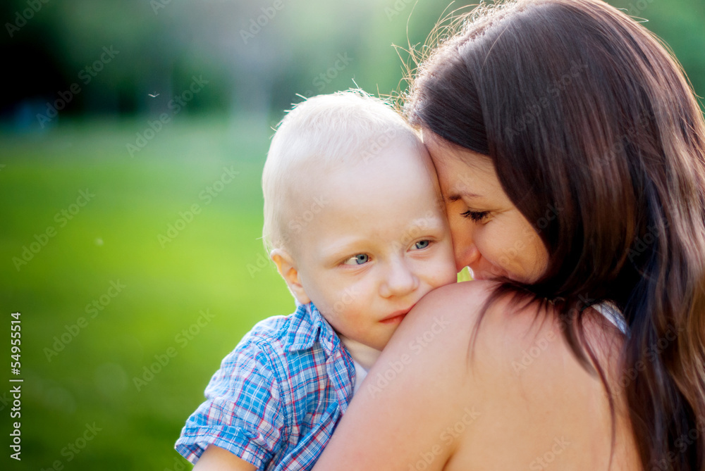 Young Mother and her little son on a nature background Young Mother and her little son on a nature background